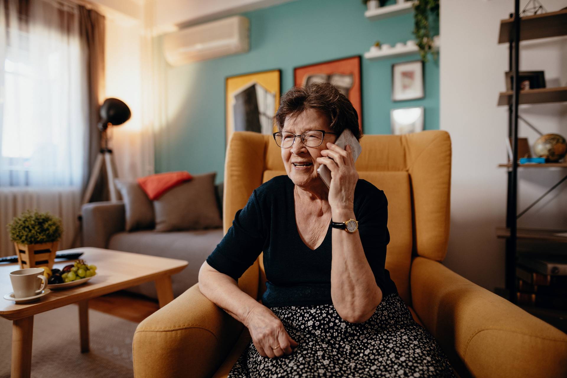 Portrait of senior woman at home using mobile phone and technologies