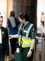 An image of a St Johns volunteer in full uniform smiling with an older woman dressed in a suit with medals