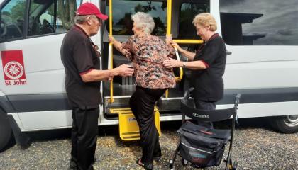 St Johns volunteers Sheryll and Jim assisting a client into the SJA minivan.