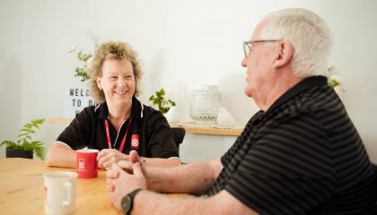 St Johns volunteer having a cup of tea with a client.