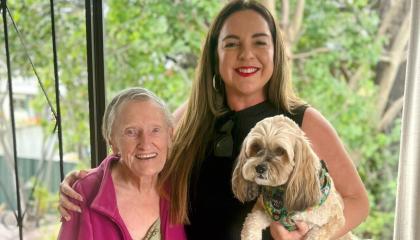 An image of Sylvia smiling at the camera alongside volunteer Alison and Sylvia's dog, Chewy.