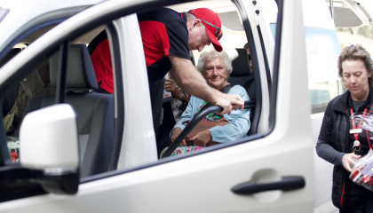 Man that works for St John helping people into a van