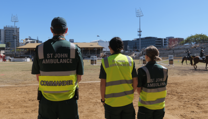 An image of three St John QLD volunteers from behind, all wearing high vis SJA uniform.