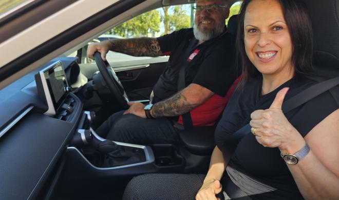 An image of community service workers in a vehicle, smiling.