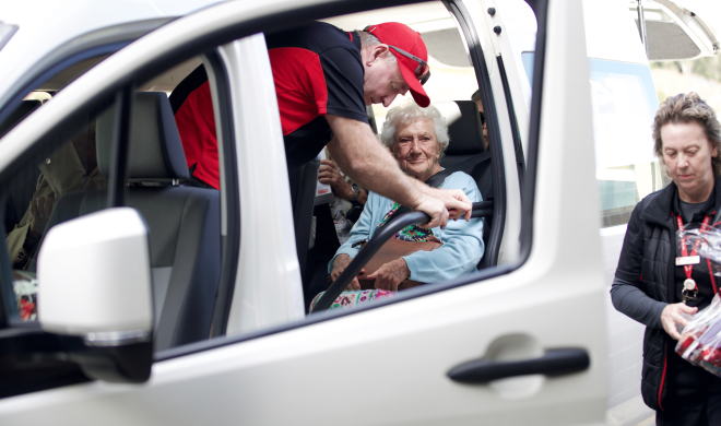 Man that works for St John helping people into a van