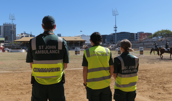 An image of three St John QLD volunteers from behind, all wearing high vis SJA uniform.