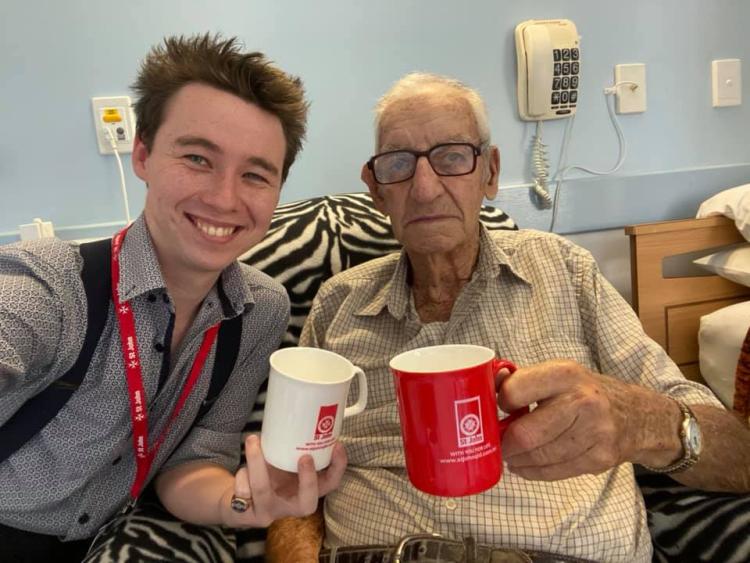 Image of St John community volunteer and client drinking tea.
